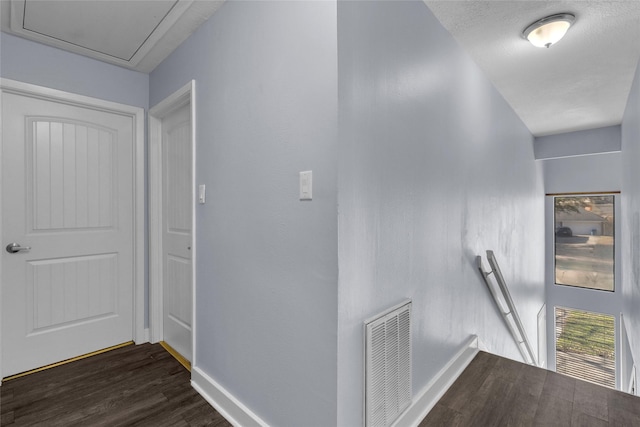 hallway with dark hardwood / wood-style floors and a textured ceiling