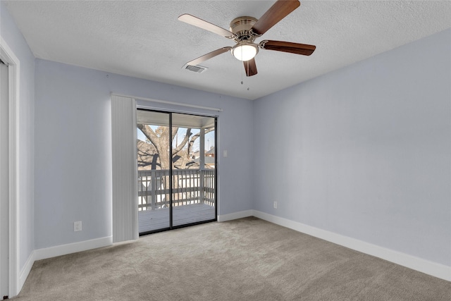 carpeted empty room with ceiling fan and a textured ceiling