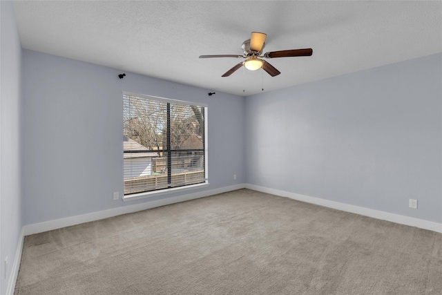 empty room featuring ceiling fan, light colored carpet, and a textured ceiling