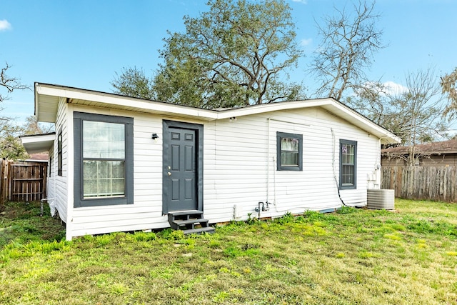 back of property with a lawn and central air condition unit