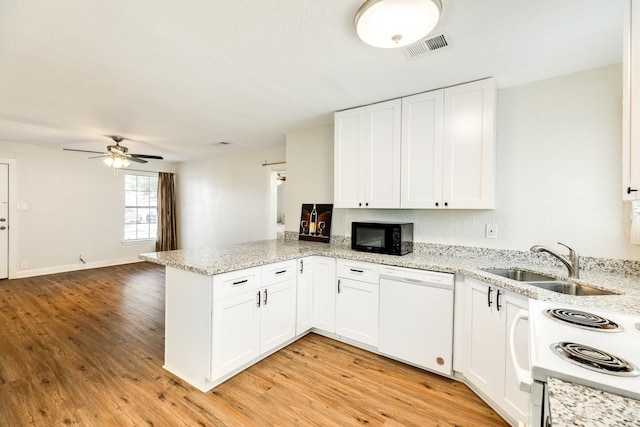 kitchen with sink, white cabinets, light hardwood / wood-style floors, kitchen peninsula, and white appliances