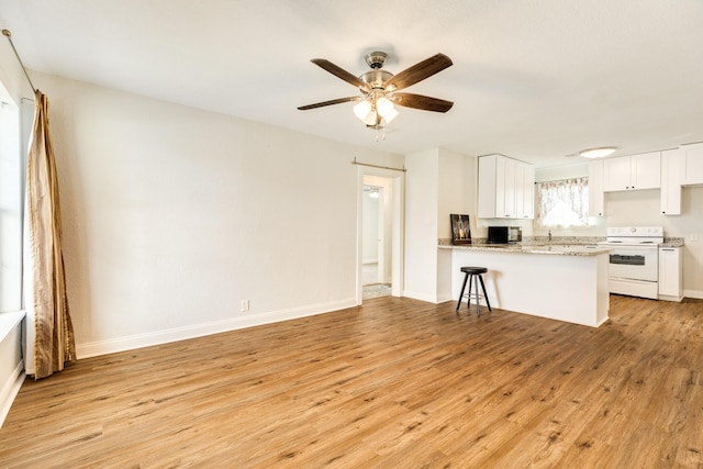 kitchen featuring white electric stove, white cabinetry, ceiling fan, kitchen peninsula, and light hardwood / wood-style flooring