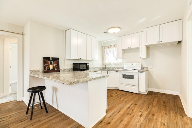 kitchen featuring light hardwood / wood-style floors, white electric stove, kitchen peninsula, and white cabinets