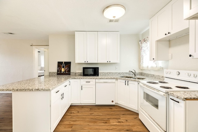 kitchen featuring sink, light wood-type flooring, kitchen peninsula, white appliances, and white cabinets