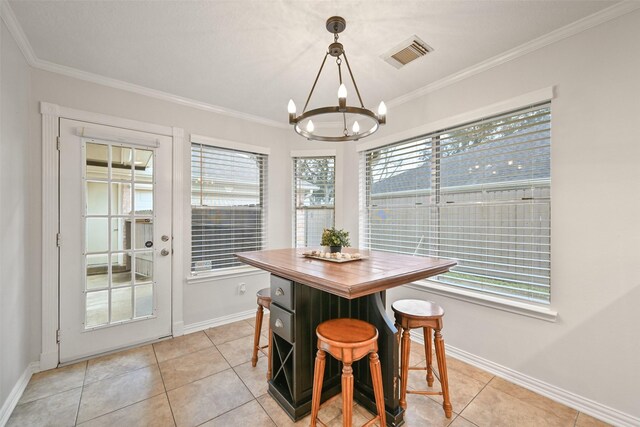 dining area featuring a notable chandelier, crown molding, and light tile patterned floors