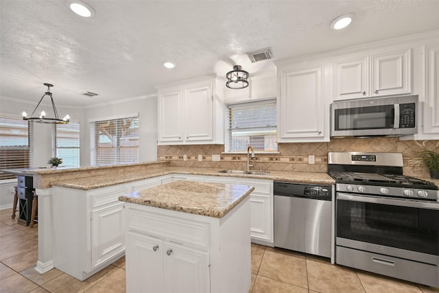 kitchen featuring a kitchen island, decorative light fixtures, sink, white cabinets, and stainless steel appliances