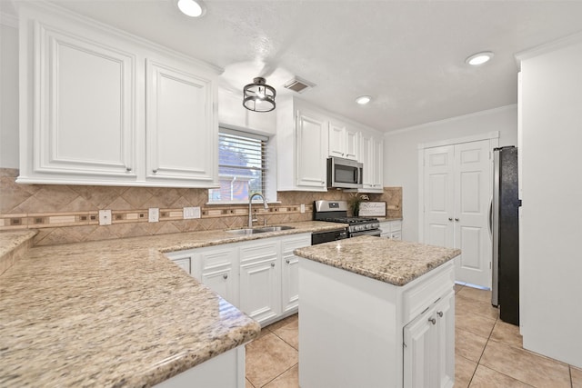 kitchen featuring visible vents, a sink, stainless steel appliances, white cabinetry, and backsplash