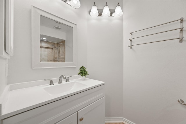 full bath featuring visible vents, walk in shower, vanity, and baseboards