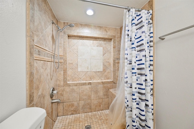 bathroom featuring toilet and a shower with shower curtain