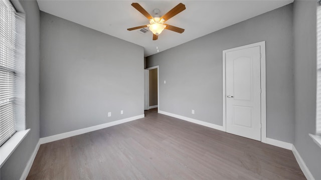 unfurnished room featuring dark hardwood / wood-style floors and ceiling fan