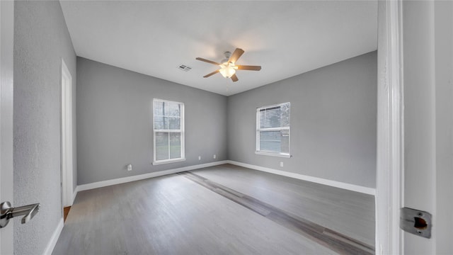 empty room with hardwood / wood-style flooring and ceiling fan