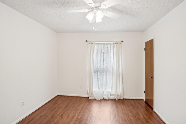 spare room with dark wood-type flooring, ceiling fan, and a textured ceiling