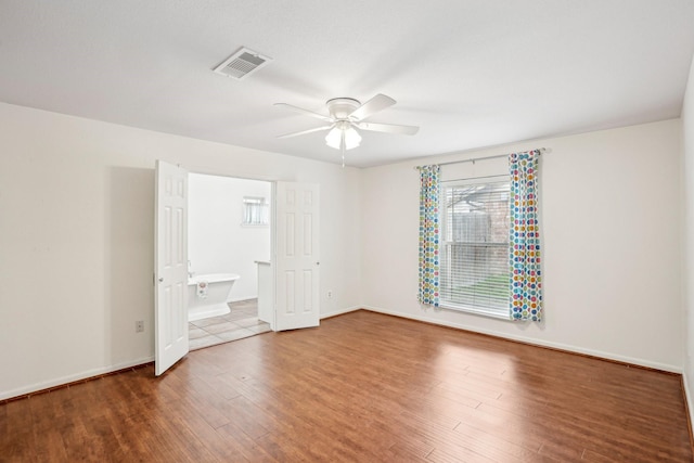 unfurnished bedroom featuring hardwood / wood-style flooring, ceiling fan, and ensuite bathroom