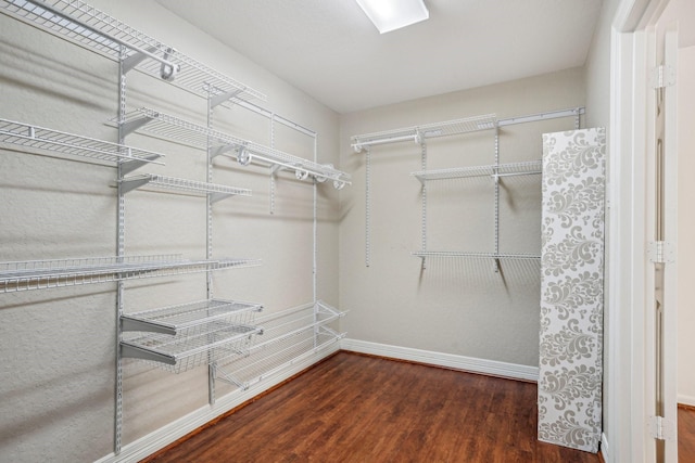 spacious closet with dark hardwood / wood-style flooring