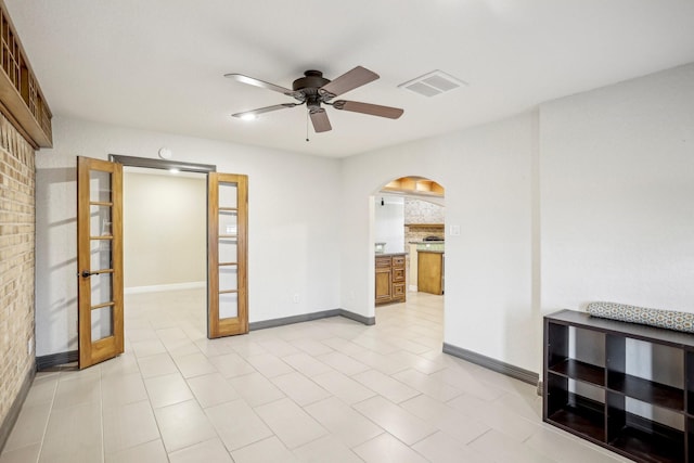 spare room with brick wall and ceiling fan