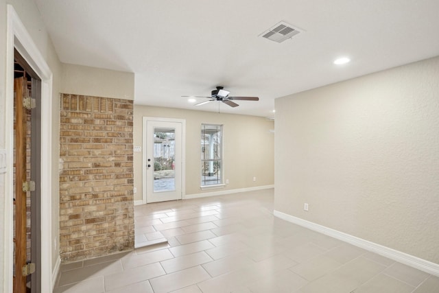 tiled empty room featuring ceiling fan