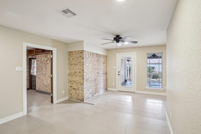 unfurnished room featuring light tile patterned flooring, brick wall, and ceiling fan