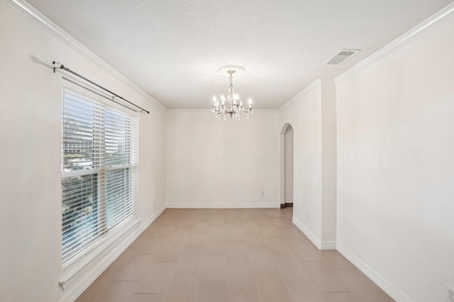 spare room featuring crown molding, a textured ceiling, and a notable chandelier