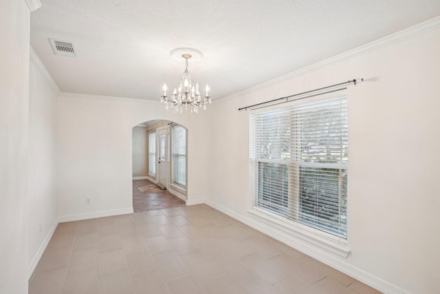 spare room featuring crown molding and a notable chandelier