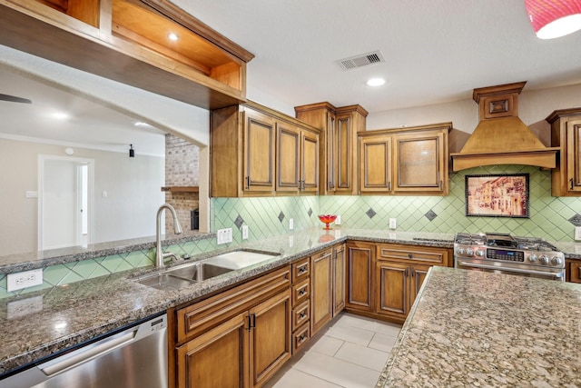 kitchen featuring sink, stone counters, stainless steel appliances, tasteful backsplash, and custom range hood