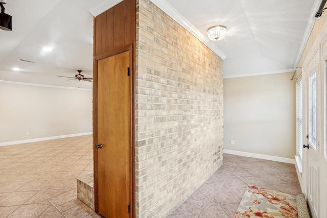 interior space with crown molding, ceiling fan, brick wall, and light tile patterned flooring