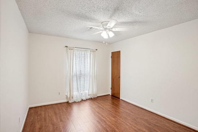 spare room with a textured ceiling, wood-type flooring, and ceiling fan