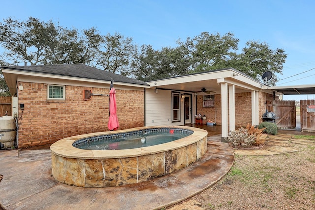 rear view of property featuring ceiling fan and a patio area