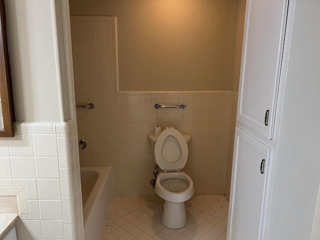 bathroom with tile walls, vanity, a tub to relax in, tile patterned floors, and toilet