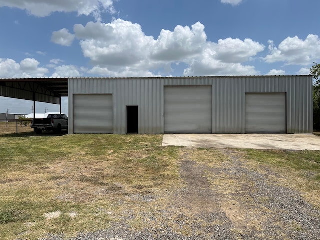 garage with a carport and a lawn