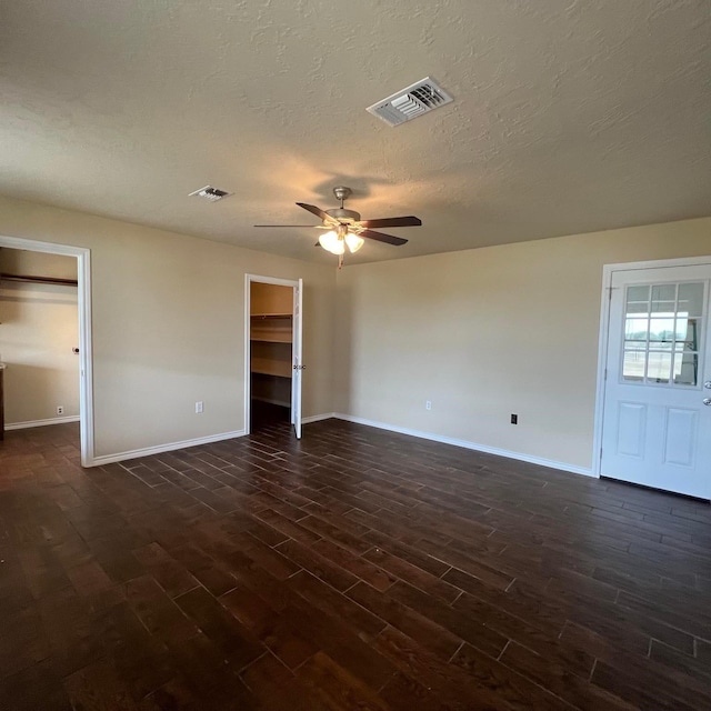 unfurnished room featuring ceiling fan, dark hardwood / wood-style floors, and a textured ceiling