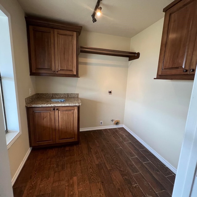 clothes washing area featuring cabinets, electric dryer hookup, track lighting, and dark hardwood / wood-style flooring