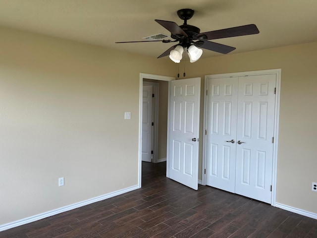 unfurnished bedroom featuring dark wood-type flooring, ceiling fan, and a closet