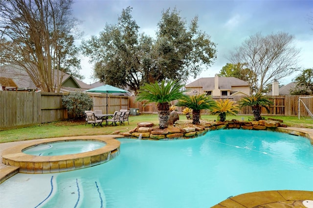 view of pool featuring a lawn and an in ground hot tub