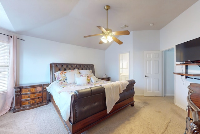 carpeted bedroom featuring lofted ceiling, connected bathroom, and ceiling fan