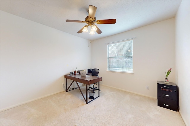 carpeted home office featuring ceiling fan