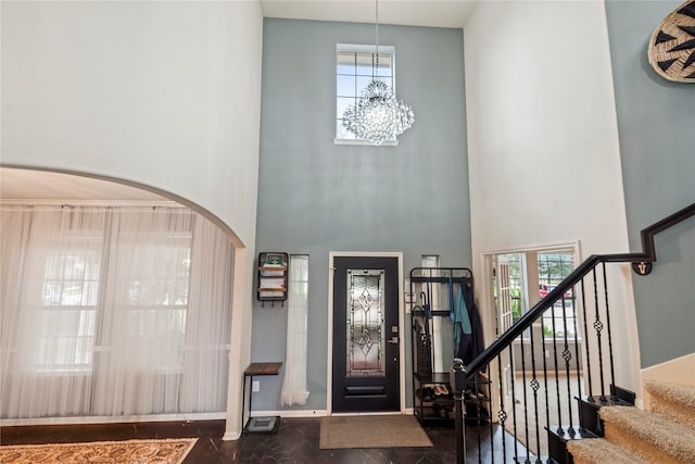 foyer entrance featuring a notable chandelier and a towering ceiling