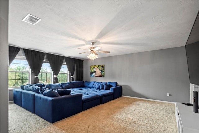 carpeted living room featuring ceiling fan and a textured ceiling