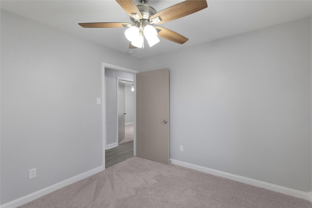 spare room featuring light carpet and ceiling fan