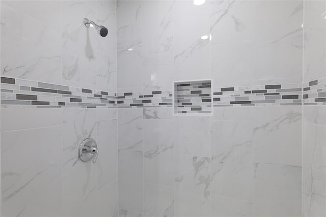 interior details with a tile shower