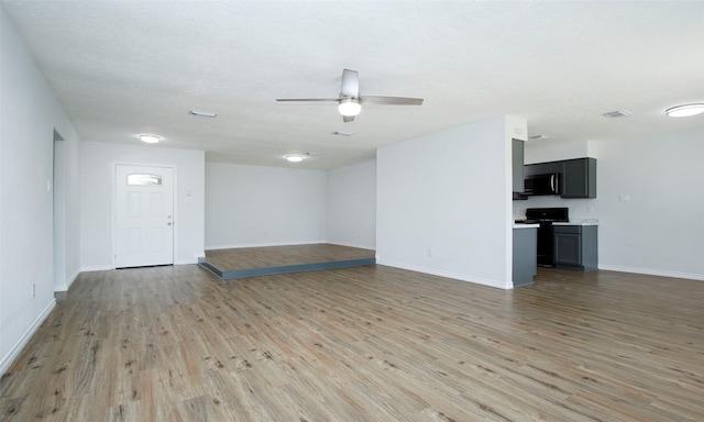 unfurnished living room featuring ceiling fan, a textured ceiling, and light hardwood / wood-style floors