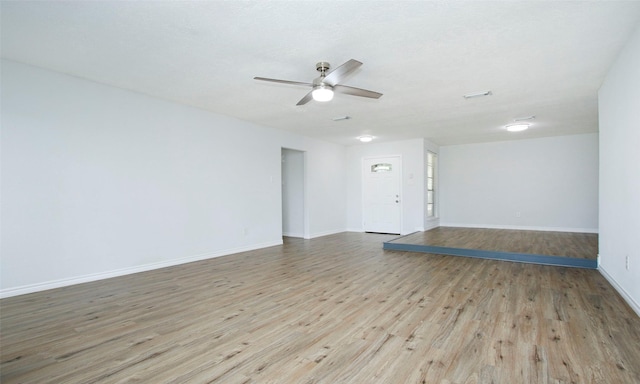 empty room with ceiling fan and light hardwood / wood-style flooring