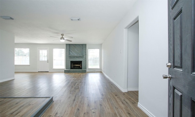 unfurnished living room featuring ceiling fan, a fireplace, and light hardwood / wood-style floors