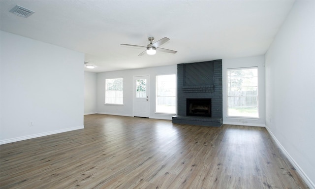 unfurnished living room featuring hardwood / wood-style flooring, a fireplace, and a wealth of natural light