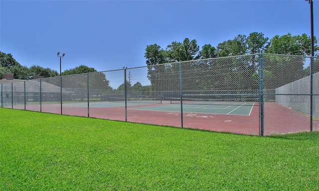 view of tennis court with a lawn