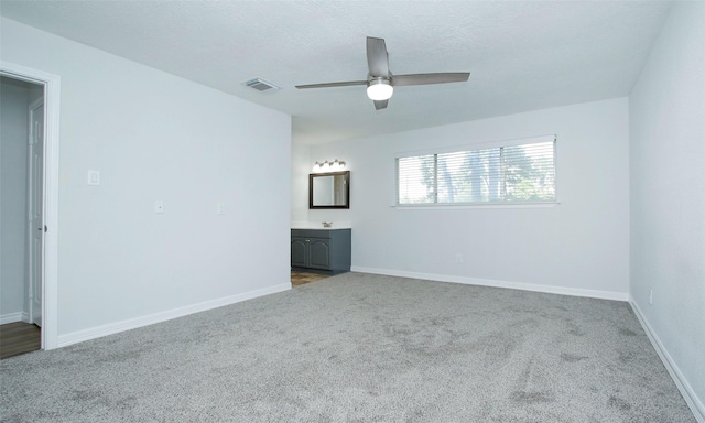 spare room featuring ceiling fan, carpet flooring, and a textured ceiling