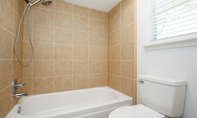 bathroom featuring tiled shower / bath and toilet