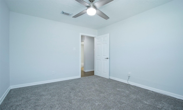 spare room with dark colored carpet and ceiling fan