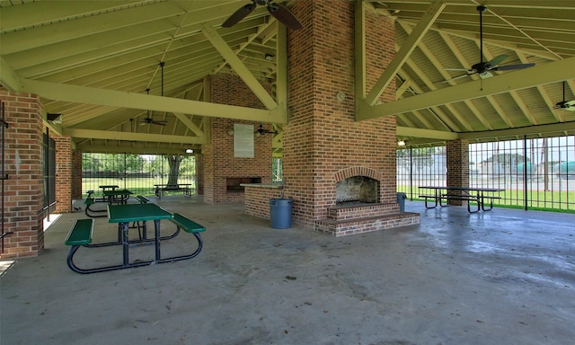 view of patio with an outdoor brick fireplace and ceiling fan