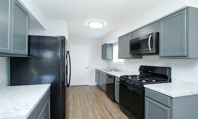 kitchen with gray cabinetry, sink, and black appliances