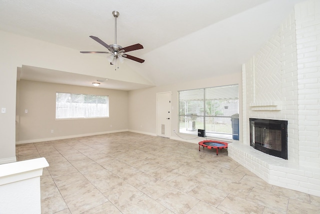 unfurnished living room with ceiling fan, vaulted ceiling, and a brick fireplace